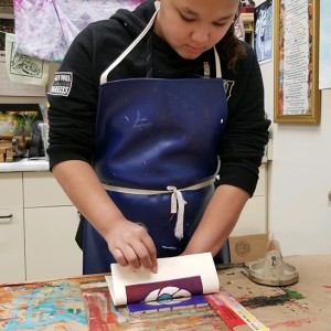 A middle school student with a reductive relief print in process.